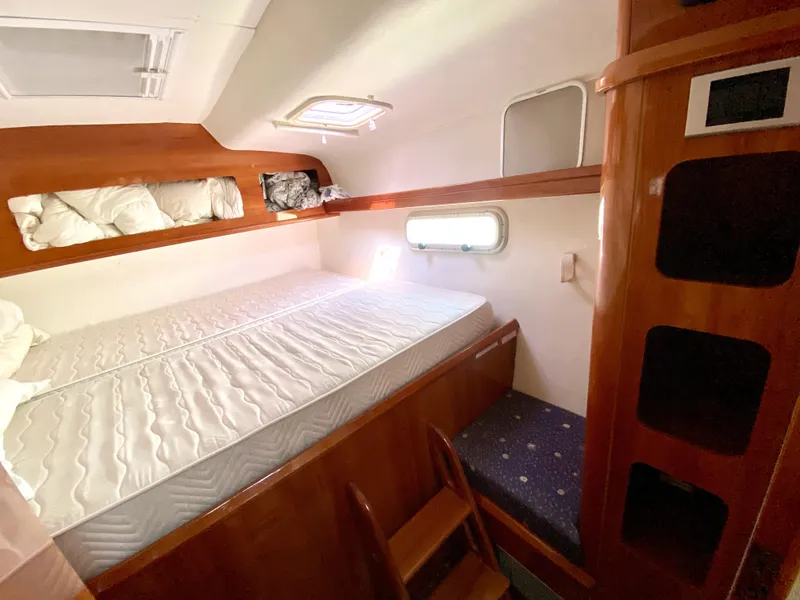 Slide: The Image of 2006 Privilege 435 yacht cabin with wooden interior, double bed, and storage shelves. - 46