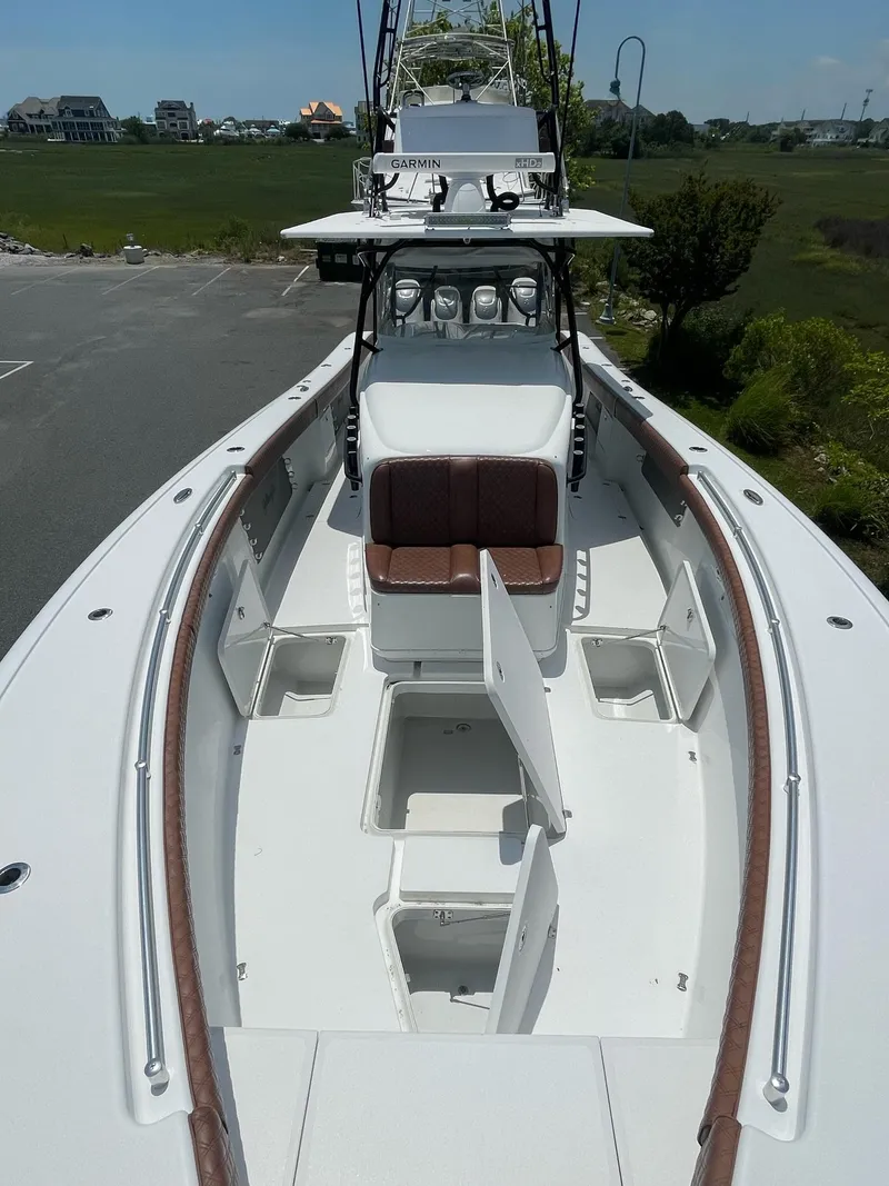 Slide: The Image of 2008 Yellowfin 42 boat with open storage compartments, docked near greenery. - 13