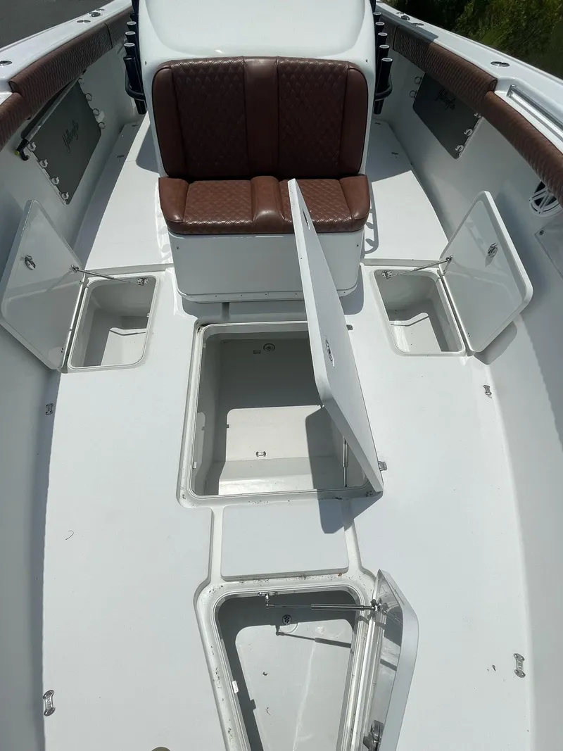 Slide: The Image of 2008 Yellowfin 42 boat interior with open storage compartments and brown seating. - 14