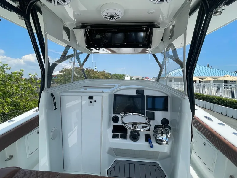 Slide: The Image of 2008 Yellowfin 42 boat cockpit with steering wheel, control panel, and clear sky background. - 19