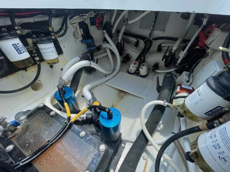 Slide: The Image of Engine compartment of a 2008 Yellowfin 42 boat, showcasing various hoses and filters. - 21