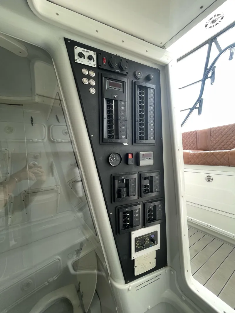 Slide: The Image of Control panel of a 2008 Yellowfin 42 boat, featuring switches and gauges. - 26