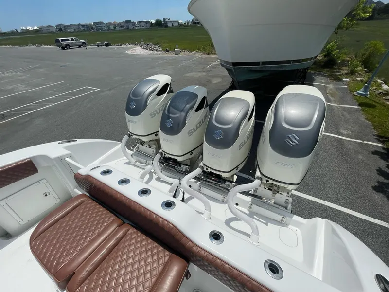 Slide: The Image of Four Suzuki outboard motors on a 2008 Yellowfin 42 boat in a parking lot. - 29