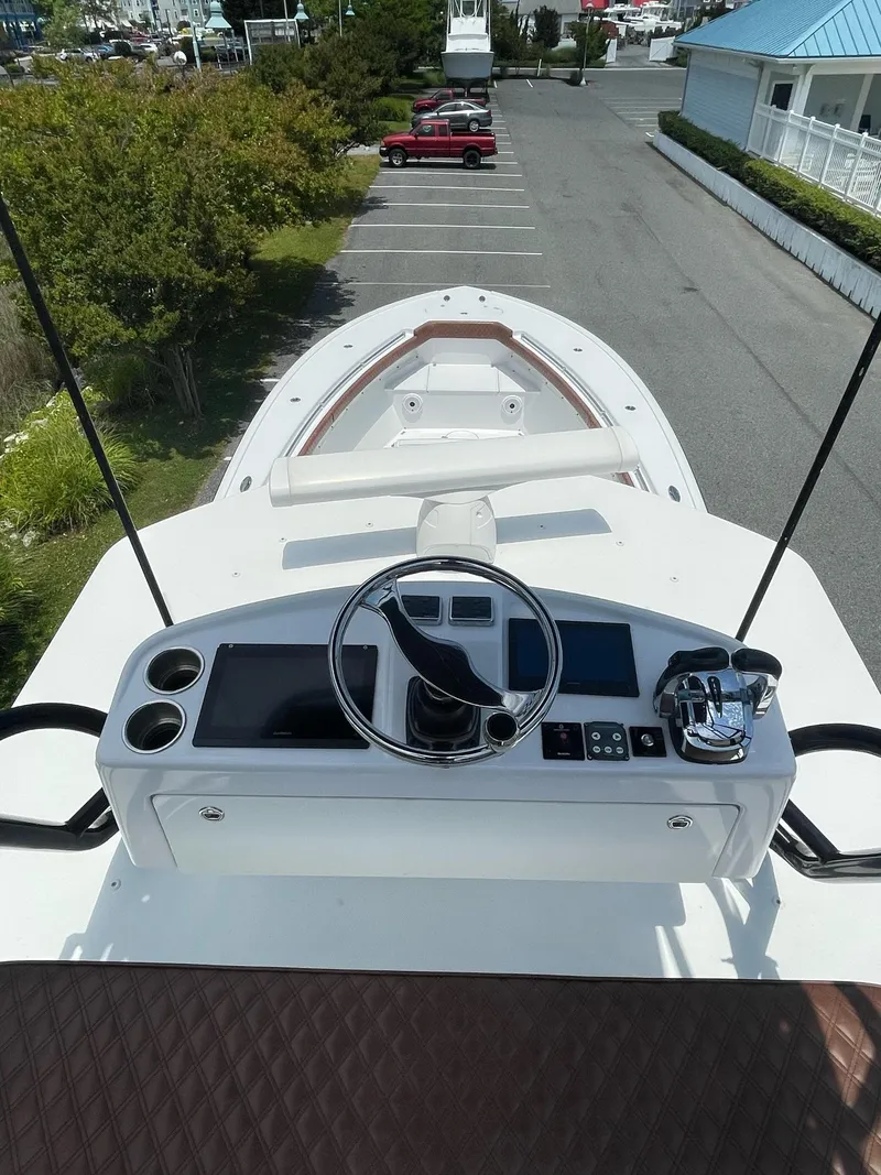 Slide: The Image of 2008 Yellowfin 42 boat helm with steering wheel and controls, docked in a parking area. - 31