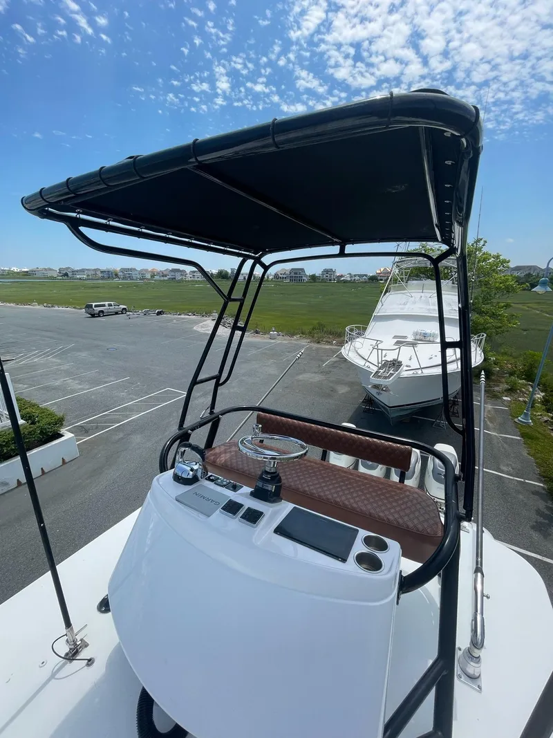 Slide: The Image of 2008 Yellowfin 42 boat helm with canopy, parked in a marina under a blue sky. - 33
