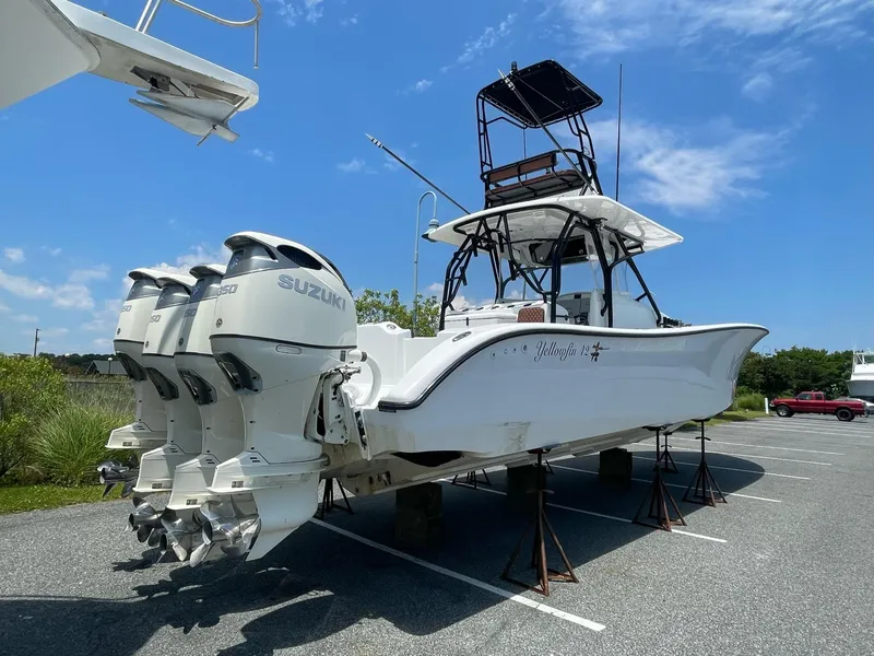 Slide: The Image of 2008 Yellowfin 42 boat with four Suzuki outboard engines, elevated on stands in a parking lot. - 7