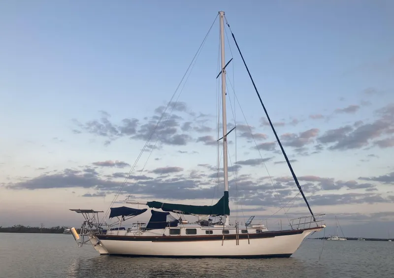 The Image of 1983 Durbeck 38 sailboat anchored on calm water at sunset. - 0