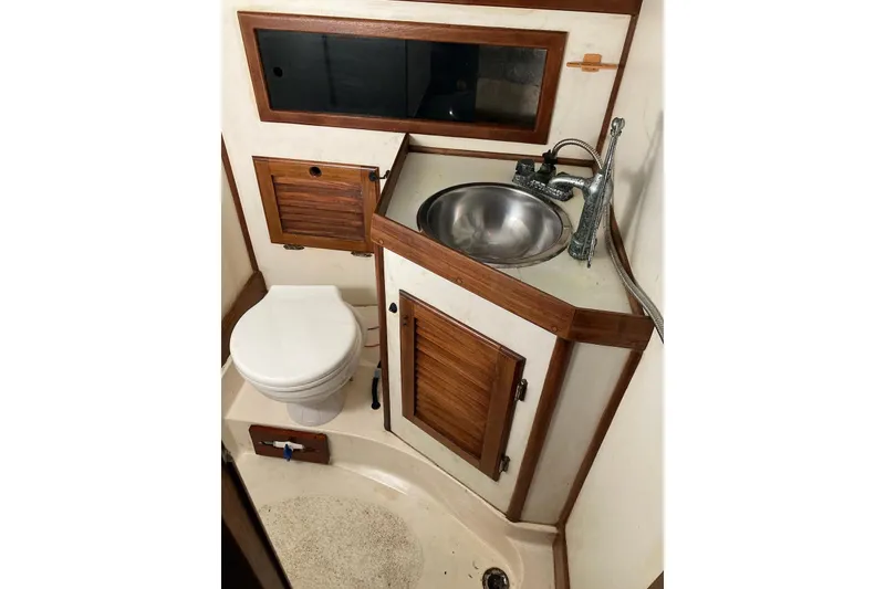 Slide: The Image of 1983 Durbeck 38 yacht bathroom with sink, toilet, and wooden cabinetry. - 25