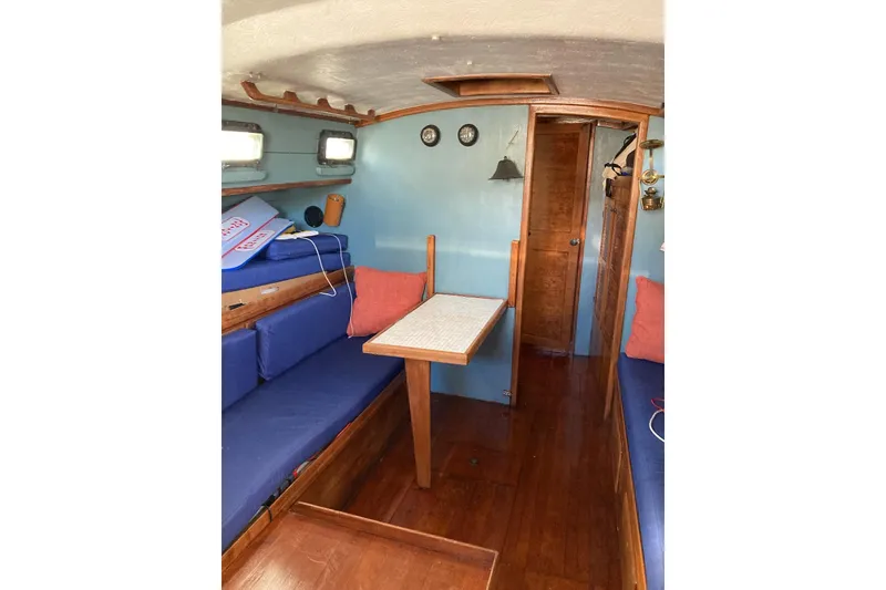 Slide: The Image of Interior of 1983 Durbeck 38 sailboat with blue seating and wooden table. - 30