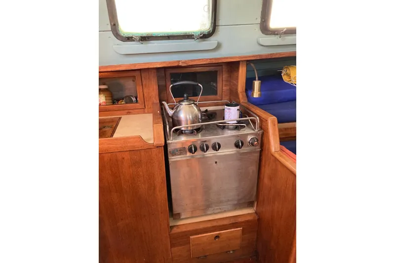 Slide: The Image of Compact kitchen area in a 1983 Durbeck 38 sailboat with stove and kettle. - 31