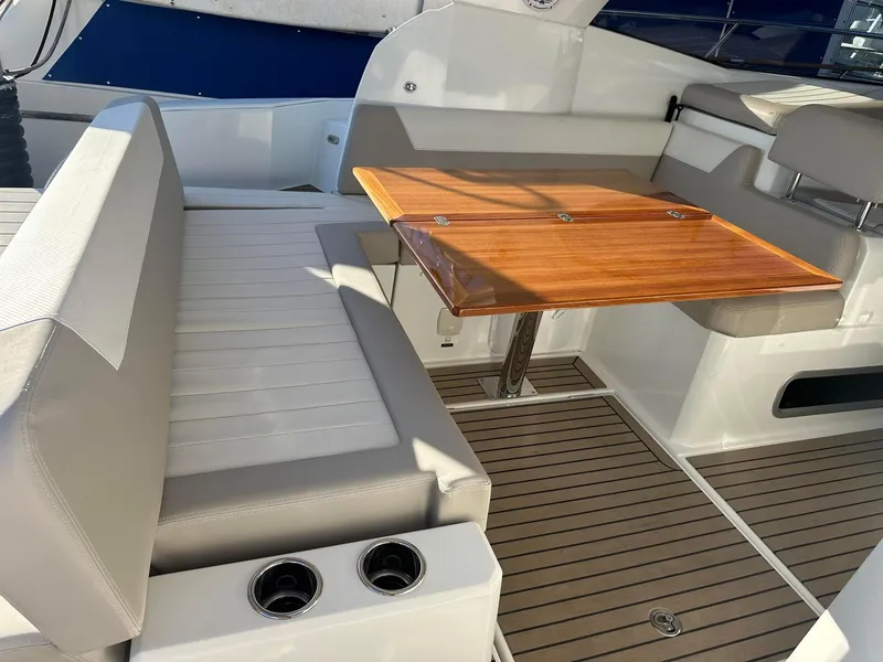 Slide: The Image of 2016 Jeanneau Leader 36 boat interior with seating and wooden table. - 10