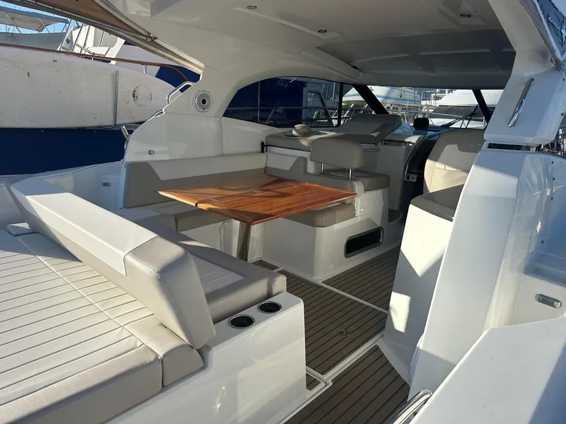 Slide: The Image of 2016 Jeanneau Leader 36 yacht interior with seating and wooden table. - 13