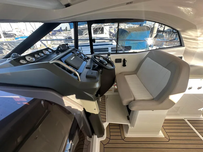 Slide: The Image of 2016 Jeanneau Leader 36 cockpit with steering wheel and seating, docked at marina. - 18