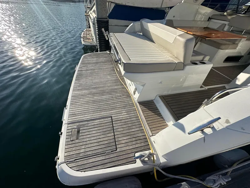 Slide: The Image of 2016 Jeanneau Leader 36 yacht with spacious deck and seating area by the water. - 8