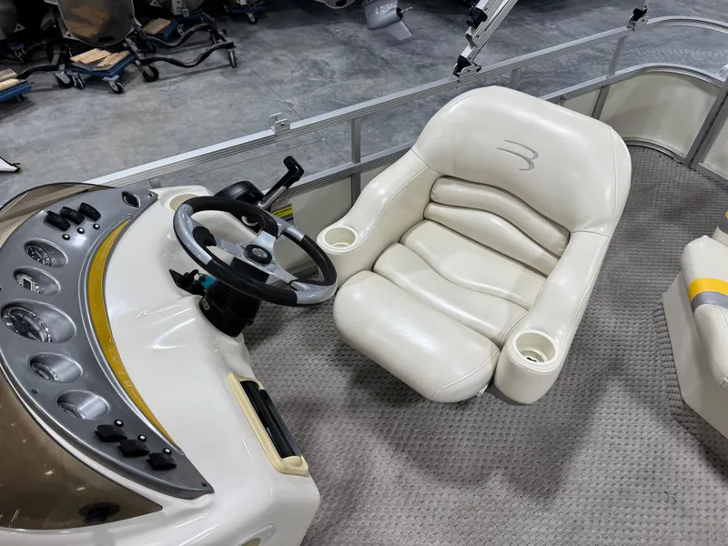 Slide: The Image of Captain's seat and helm of 2005 Bennington 2275 RL boat, featuring plush white upholstery. - 11