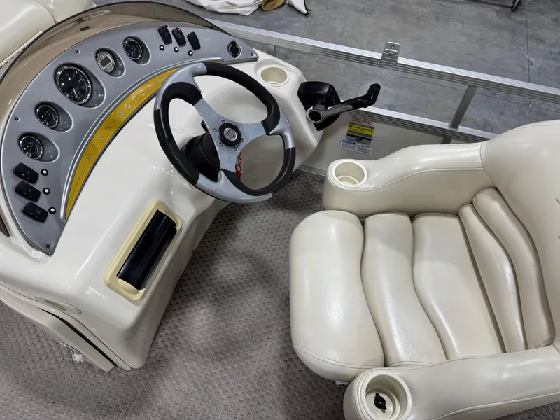 Slide: The Image of 2005 Bennington 2275 RL boat dashboard with steering wheel and plush captain's chair. - 13
