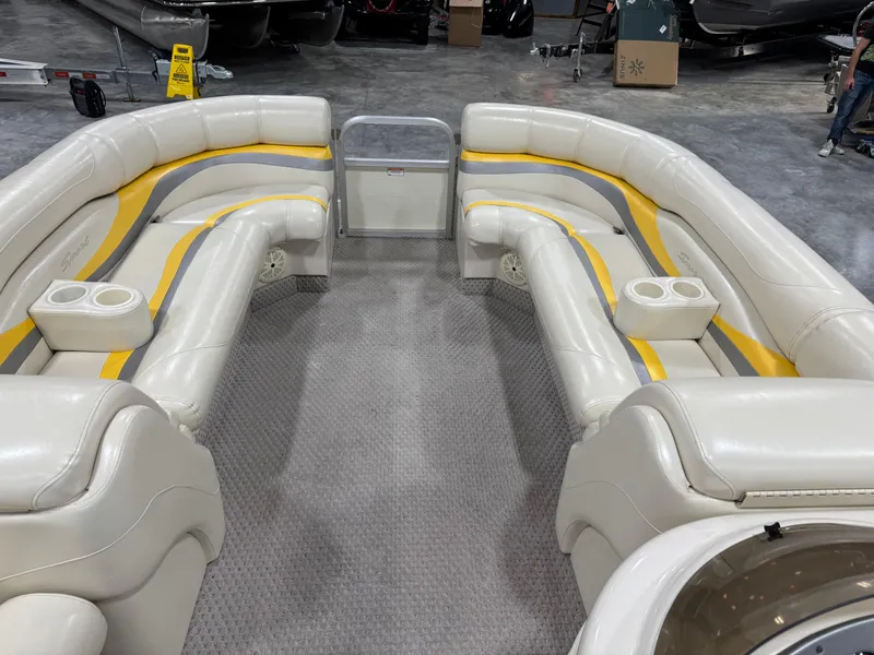 Slide: The Image of 2005 Bennington 2275 RL pontoon boat interior with beige and yellow seating, cup holders, and carpeted floor. - 14