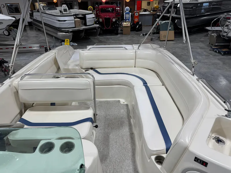 Slide: The Image of 2001 Bayliner 26 Rendevous boat interior with white seating and blue accents in a showroom. - 14