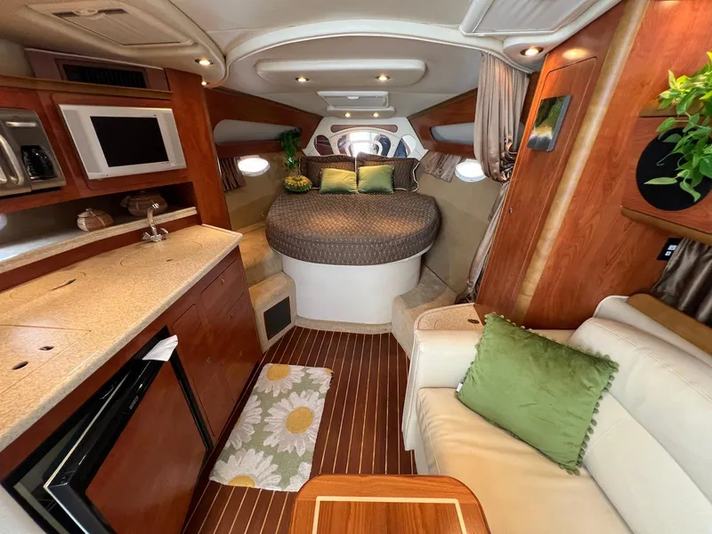 Slide: The Image of 2007 Rinker 350 Express Cruiser interior with cozy bed, kitchenette, and seating area. - 13
