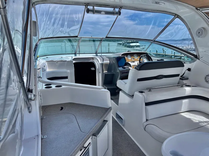 Slide: The Image of 2007 Rinker 350 Express Cruiser interior with helm, seating, and dashboard under clear skies. - 2