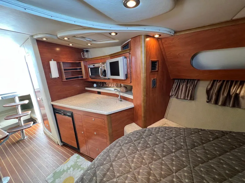 Slide: The Image of 2007 Rinker 350 Express Cruiser interior with kitchenette and cozy sleeping area. - 23