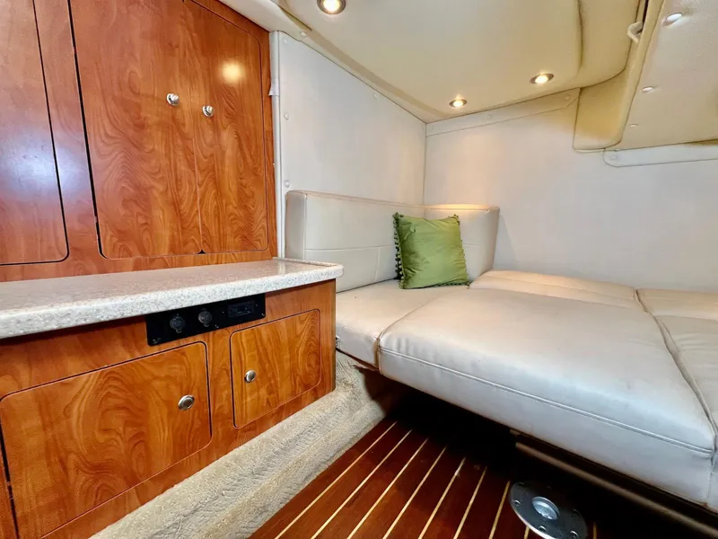 Slide: The Image of 2007 Rinker 350 Express Cruiser interior with wood cabinetry and cushioned seating. - 25