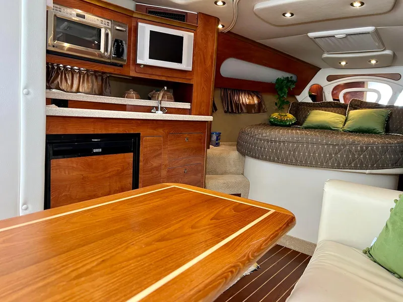 Slide: The Image of 2007 Rinker 350 Express Cruiser interior with kitchenette and cozy seating area. - 26