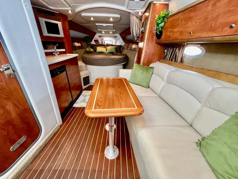 Slide: The Image of 2007 Rinker 350 Express Cruiser interior with wood accents, cozy seating, and modern amenities. - 27