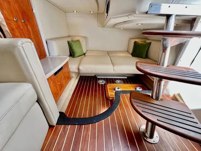 Slide: The Image of 2007 Rinker 350 Express Cruiser interior with wooden flooring and cozy seating area. - 28