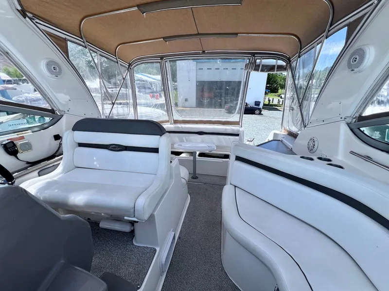Slide: The Image of 2007 Rinker 350 Express Cruiser interior with white seating and clear canopy. - 4