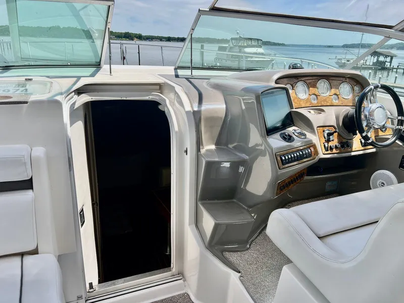 Slide: The Image of 2007 Rinker 350 Express Cruiser helm with open cabin door, featuring modern controls and steering. - 5