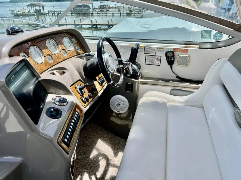 Slide: The Image of 2007 Rinker 350 Express Cruiser helm with gauges, steering wheel, and white seating. - 6
