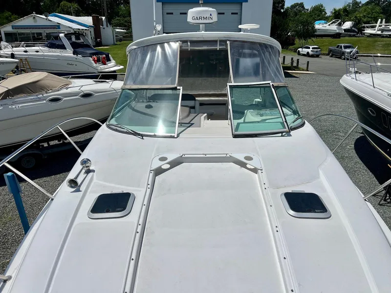 Slide: The Image of 2007 Rinker 350 Express Cruiser boat docked, featuring a spacious deck and windshield. - 9