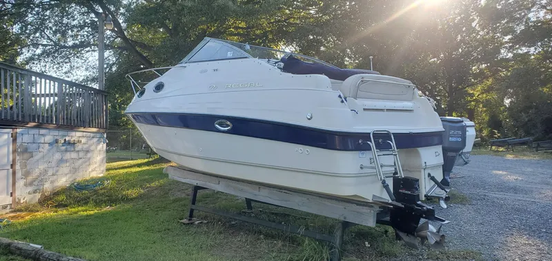 Slide: The Image of 1999 Regal Commodore 242 boat on trailer, parked outdoors in sunlight. - 1
