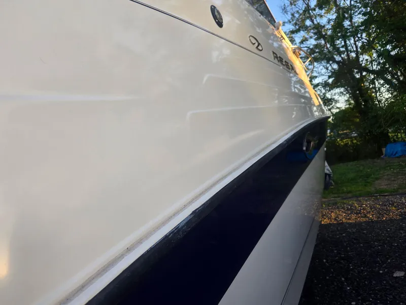 Slide: The Image of 1999 Regal Commodore 242 boat side view with sleek white and blue design. - 10