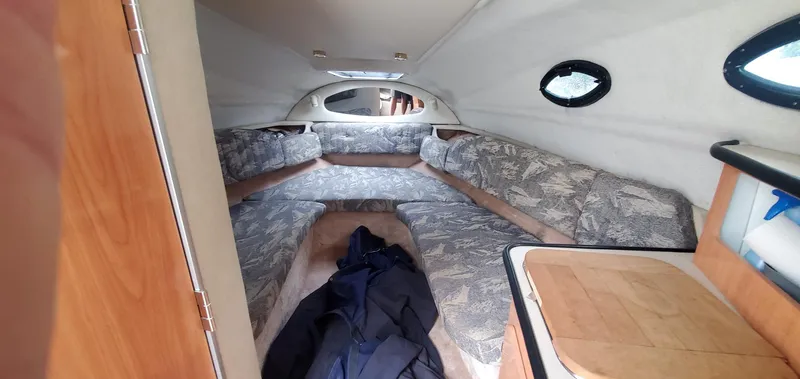 Slide: The Image of 1999 Regal Commodore 242 cabin interior with patterned seating and small windows. - 11