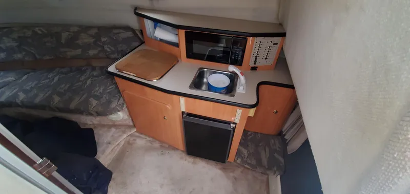 Slide: The Image of 1999 Regal Commodore 242 cabin interior with kitchenette and bed. - 13