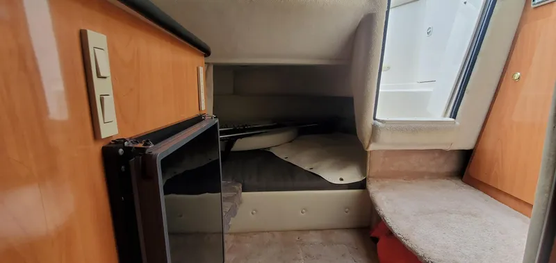 Slide: The Image of 1999 Regal Commodore 242 cabin interior with compact fridge and seating area. - 14