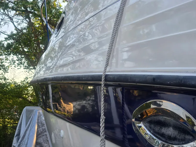 Slide: The Image of 1999 Regal Commodore 242 boat side view with rope, surrounded by trees. - 6