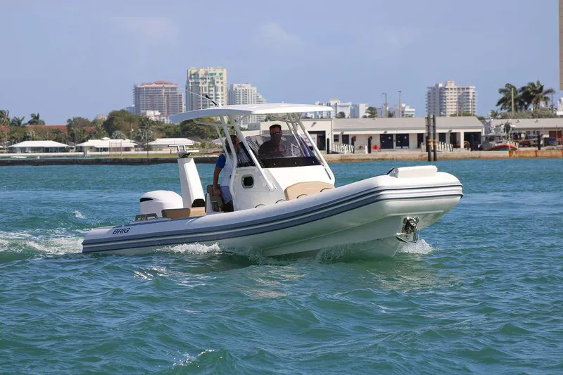The Image of 2026 Brig Eagle 8 boat cruising on clear blue water near urban skyline. - 0