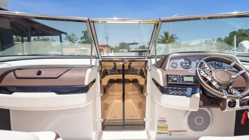 Slide: The Image of Interior view of a 2016 Regal 2300 boat cockpit with steering wheel and dashboard controls. - 14