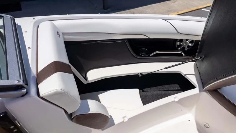 Slide: The Image of 2016 Regal 2300 boat interior with white and brown seating, open storage compartment. - 16