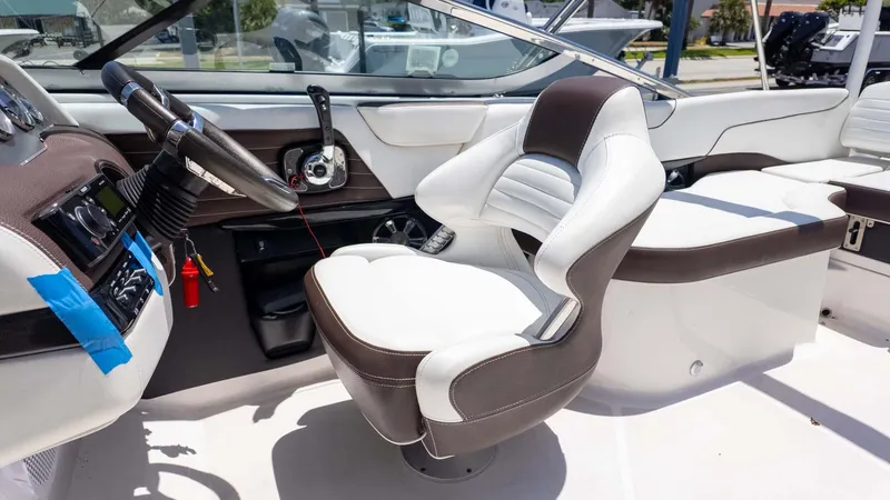 Slide: The Image of Interior of a 2016 Regal 2300 boat featuring a sleek steering wheel and comfortable seating. - 17