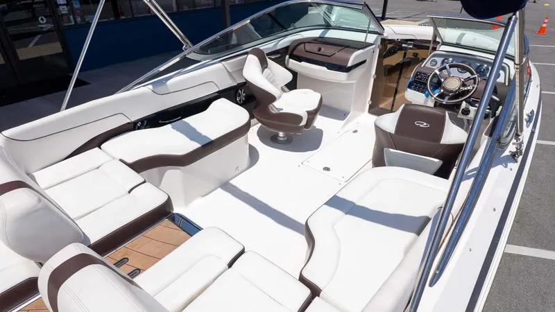 Slide: The Image of 2016 Regal 2300 boat interior with white and brown seating, steering wheel, and dashboard. - 7