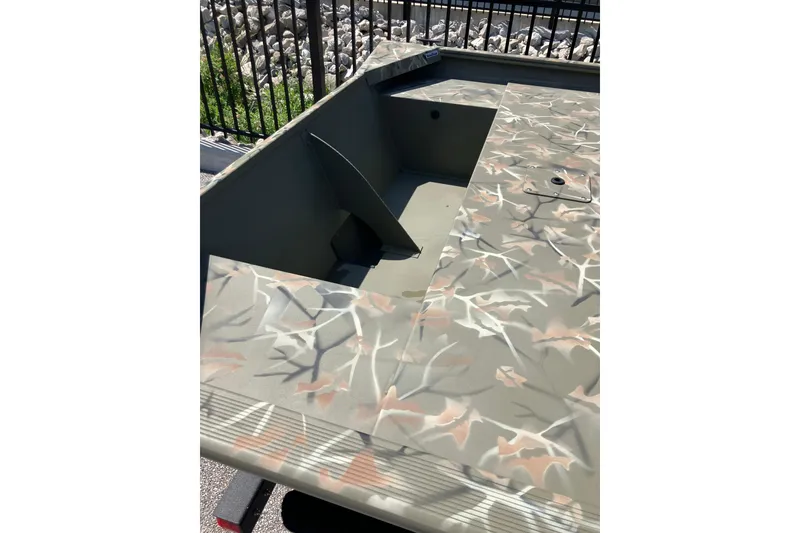 Slide: The Image of 2025 Tracker Grizzly 1754 Jon boat with camouflage pattern, featuring a spacious deck. - 2
