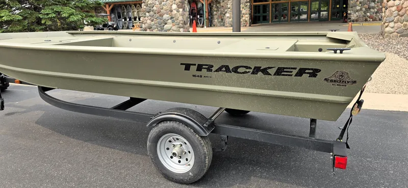 Slide: The Image of 2025 Tracker Grizzly 1648 Jon boat on trailer, parked outdoors. - 10