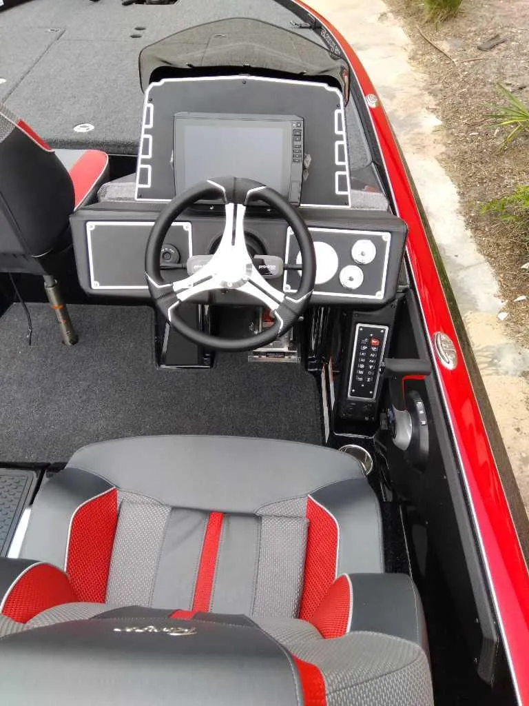 Slide: The Image of 2025 Ranger Z520 boat cockpit with steering wheel, dashboard, and red-gray seating. - 4