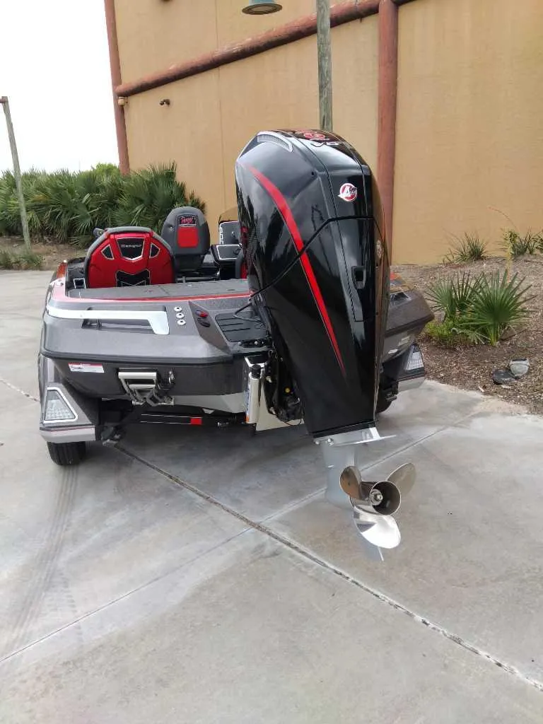 Slide: The Image of 2025 Ranger Z520 boat with powerful outboard motor, parked on concrete near a building. - 6