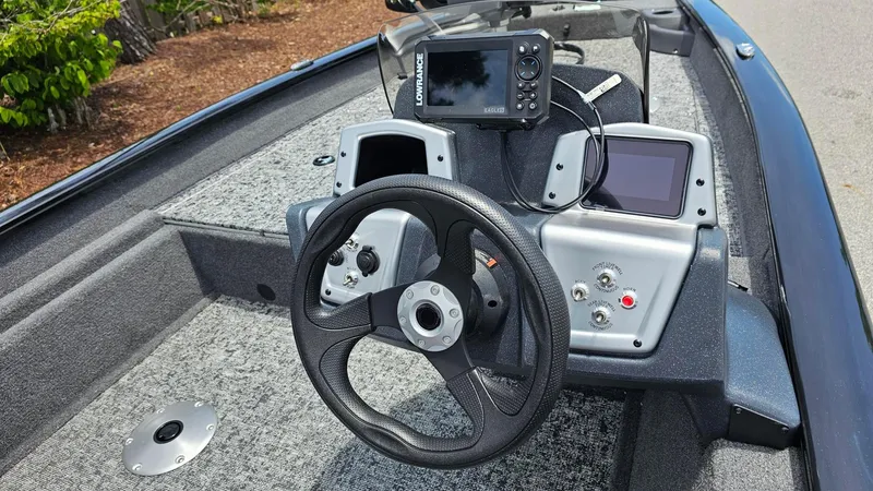 Slide: The Image of 2025 Tracker Pro Team 175 Crappie Edition boat dashboard with steering wheel and electronic displays. - 9