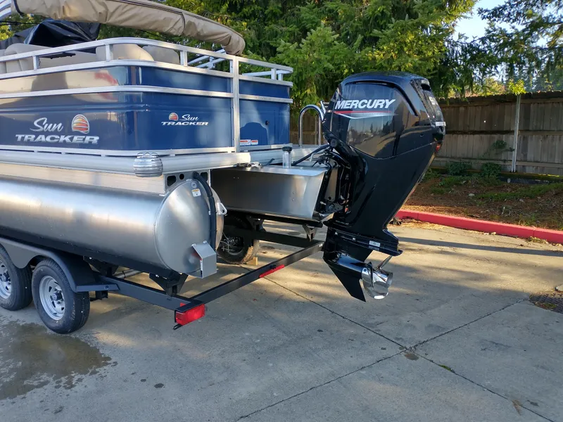 Slide: The Image of 2025 Sun Tracker Fishin' Barge 20 DLX with Mercury outboard motor on trailer. - 2